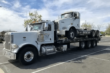 Truck hauling another truck on a flatbed
